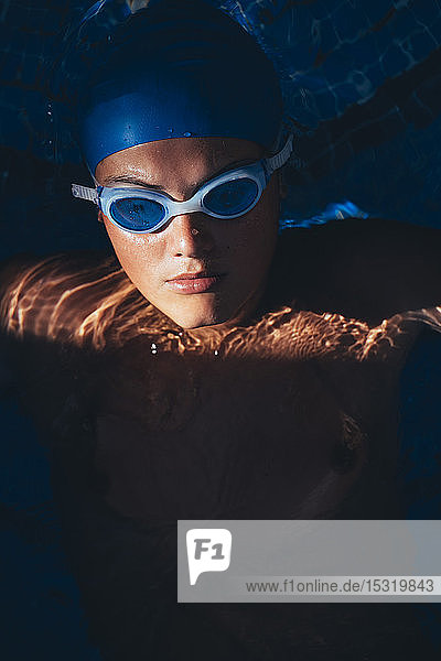 Porträt einer jungen paralympischen Schwimmerin in einem Schwimmbad
