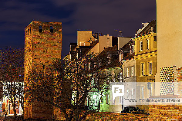 Stadtmauerturm und traditionelle Häuser bei Nacht Warschau Polen