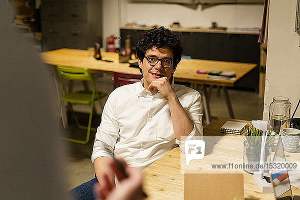 Smiling businessman looking at colleague in office