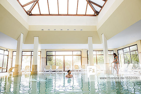 Couple relaxing in swimming pool of a spa