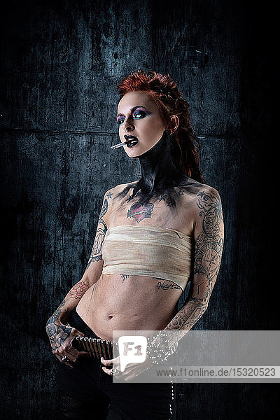 Young tattooed woman  one-eyed  a cigarette in her hand