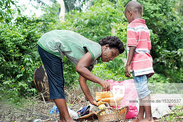 the young woman instead of food in a basket assisted by her child standing next to her.
