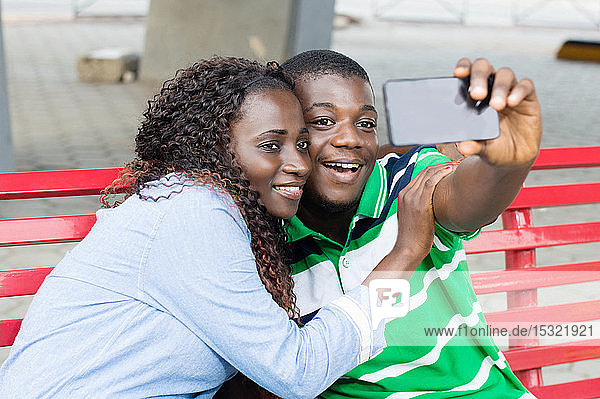 Ein junges Paar macht Fotos  um ihre Fahrt auf dem öffentlichen Platz zu markieren.