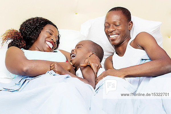 this family lying in bed is happy to share good holiday together