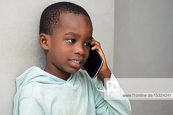 Dieses Kind am Telefon  hört aufmerksam seinem Gesprächspartner zu.