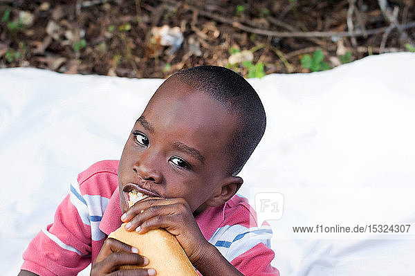 dieses Kind Ausgang entspannt mit seinen Eltern gibt Freude mit einem Stück Brot.