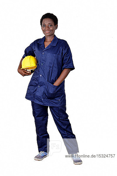 Junger lächelnder Bauarbeiter  der seinen Helm auf weißem Hintergrund hält.