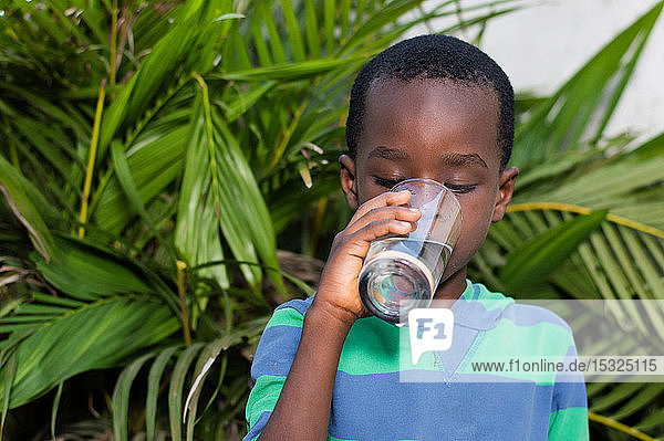 Boy drinking mineral water in a glass.