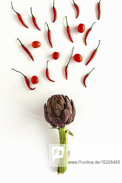 Rotes Gemüse: Chilis Tomaten und Artischocke auf weißem Untergrund