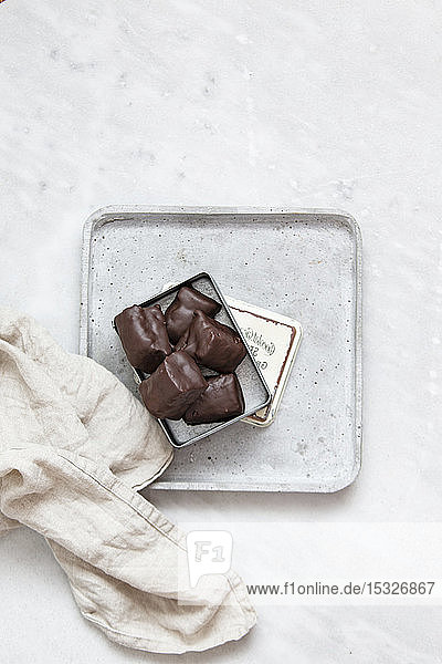 Schokoladenpralinen mit Nüssen und Datteln in Geschenkbox auf weißem Marmorhintergrund