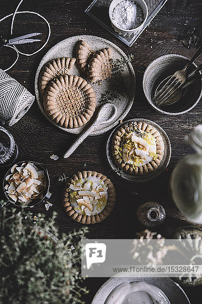 Kuchentörtchen mit Vanillepudding und Kokoschips auf rustikalem Hintergrund