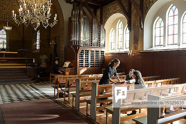 Priests talking on church pews
