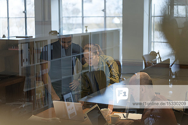 View through window of businesspeople in meeting