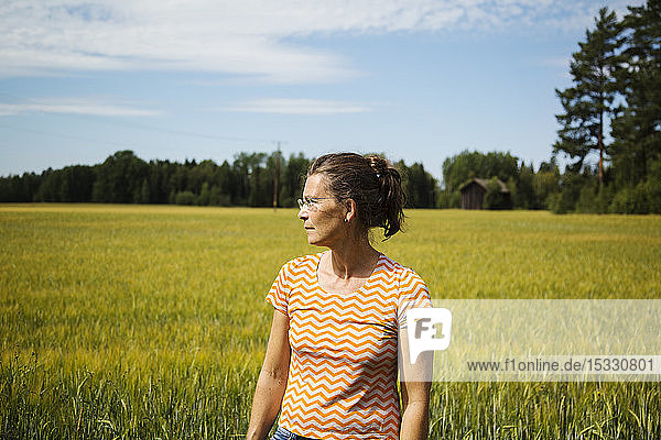 Frau auf einem Feld in der Landschaft von Dalarna  Schweden