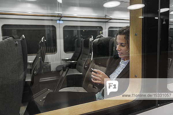 Woman using smart phone on train