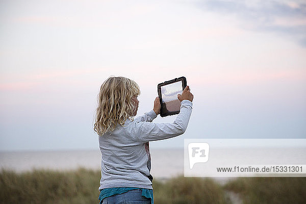 Girl taking photograph with tablet PC