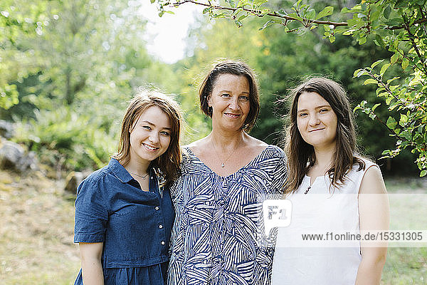 Portrait of mother and daughters in forest