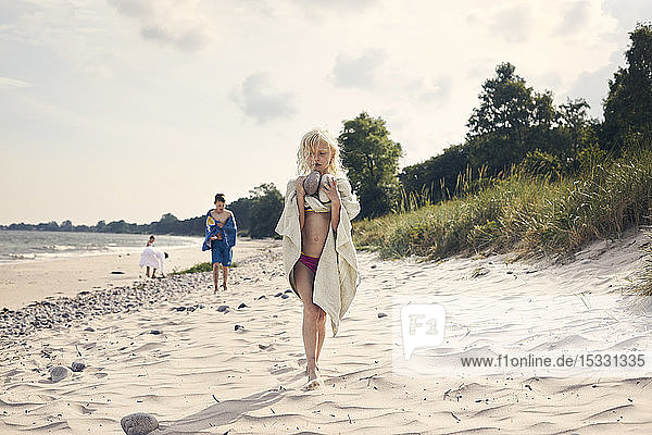 Girl carrying rocks on beach