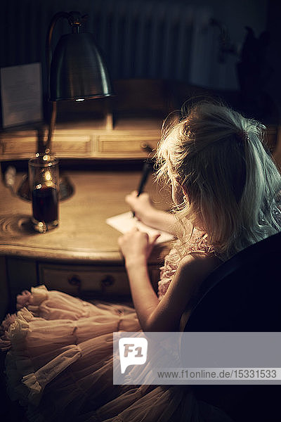 Girl writing at letter at desk