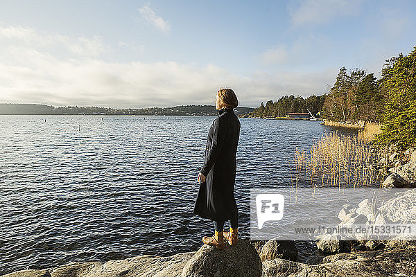 Young woman standing next to lake
