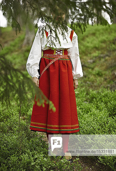 Frau in rotem Kostüm auf einem Feld