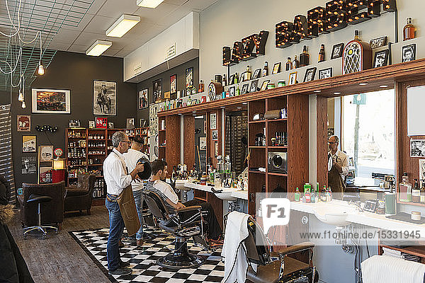 Barbers cutting customer´s hair
