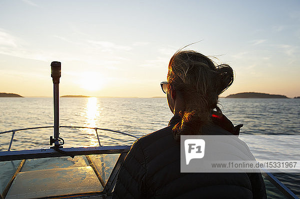 Woman on boat at sunset