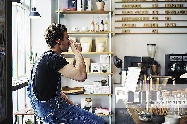 Young man drinking coffee in cafe