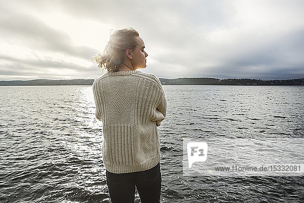 Young woman standing next to lake
