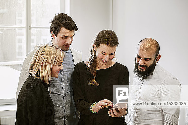 Coworkers looking at smart phone