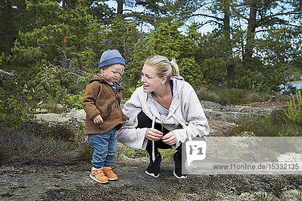 Young woman with daughter by forest