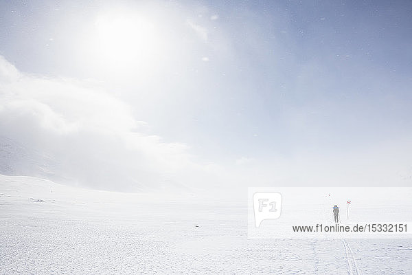 Frau beim Skifahren mit Markierungen auf der Kungsleden-Loipe in Lappland, Schweden