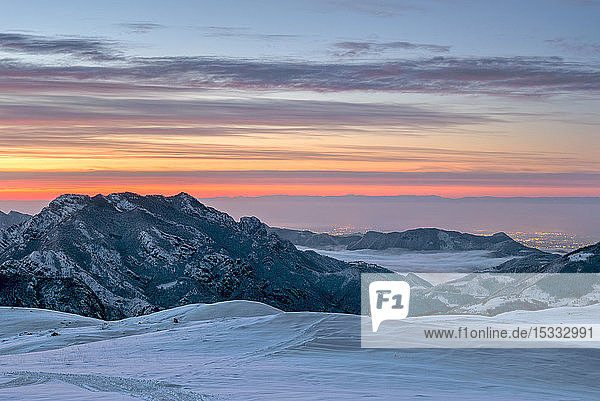 Italien  Lombardei  Regionalpark Orobie-Alpen  Berg Sordanello (1580 m) bei Sonnenaufgang von Piani d'Alben (1650 m) aus  bg.: die Lichter der Poebene