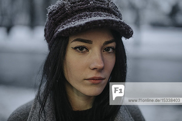 Portrait of young woman wearing woolly hat and eyeliner