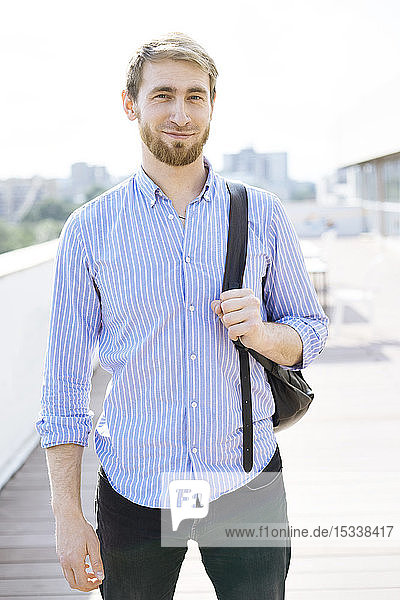 Bearded man wearing striped shirt and backpack