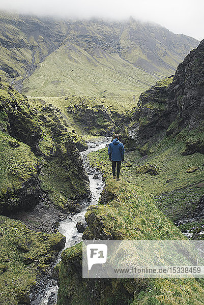 Man hiking by valley river in Iceland