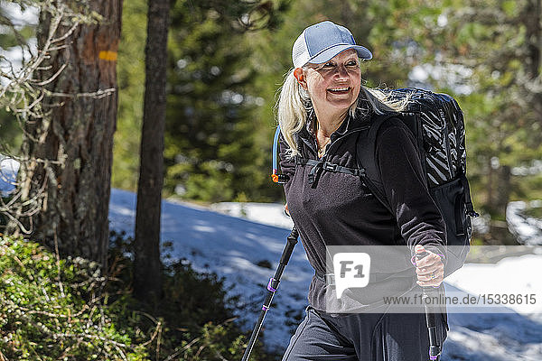 Ältere Frau beim Wandern zwischen Bäumen auf dem Munkelweg in Val di Funes  Italien