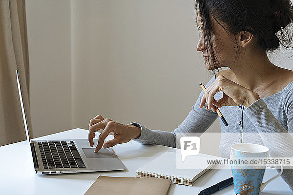 Woman using laptop working at home