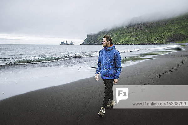 Man walking on beach in Vik  Iceland