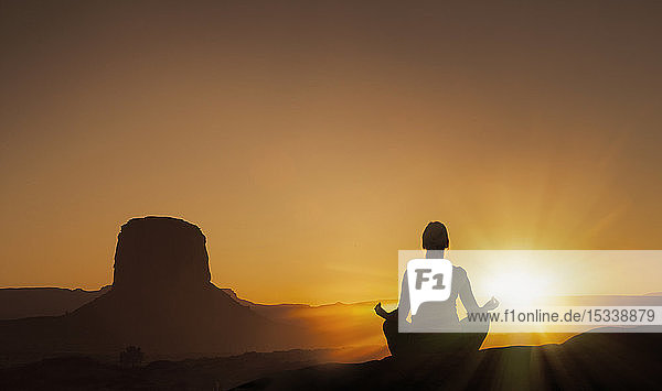 Frau meditiert bei Sonnenuntergang im Monument Valley Navajo Tribal Park  USA