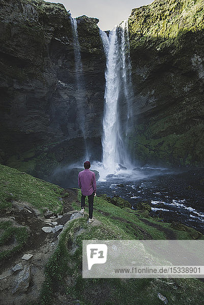 Mann am Kvernufoss-Wasserfall in Island