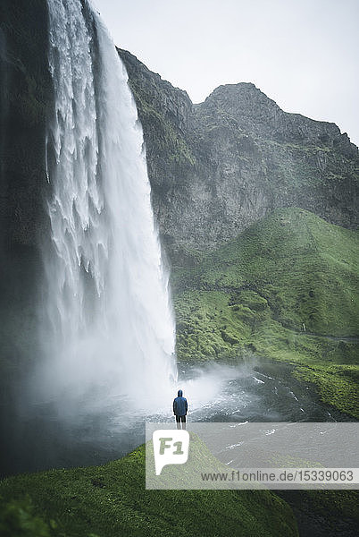 Mann am Seljalandsfoss-Wasserfall in Island
