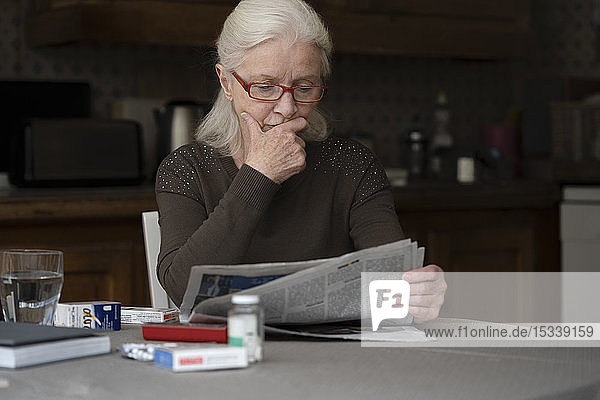 Ältere Frau liest Zeitung