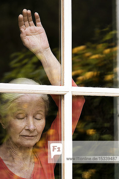 Frau schaut durch das Fenster