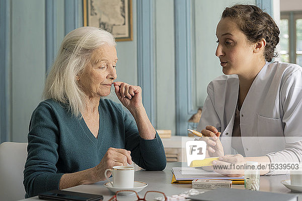 Doctor showing pill box to patient