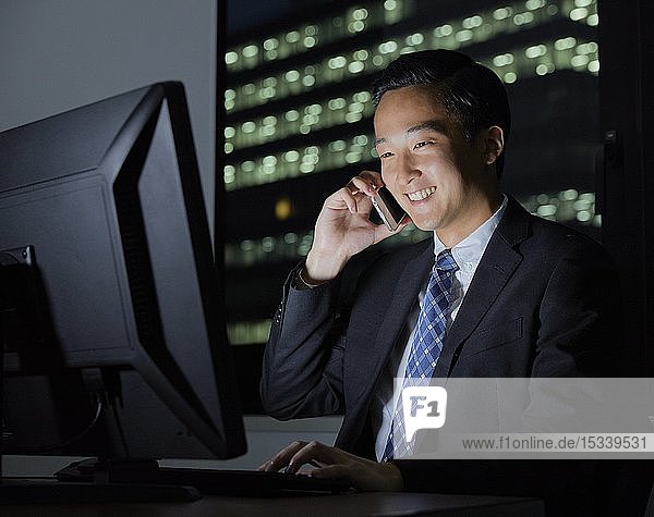 Young Japanese businessman working late at night