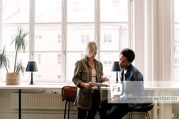 Geschäftskollegen besprechen Dokument während ihrer Arbeit im Büro