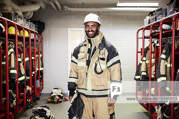 Portrait of smiling male firefighter in locker room at fire station