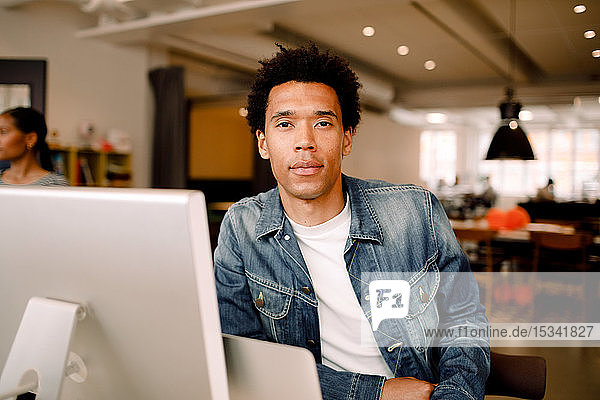 Porträt eines selbstbewussten jungen Geschäftsmannes  der im Amt sitzt