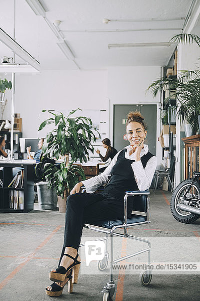 Porträt einer selbstbewussten reifen Geschäftsfrau  die auf einem Stuhl im Büro sitzt